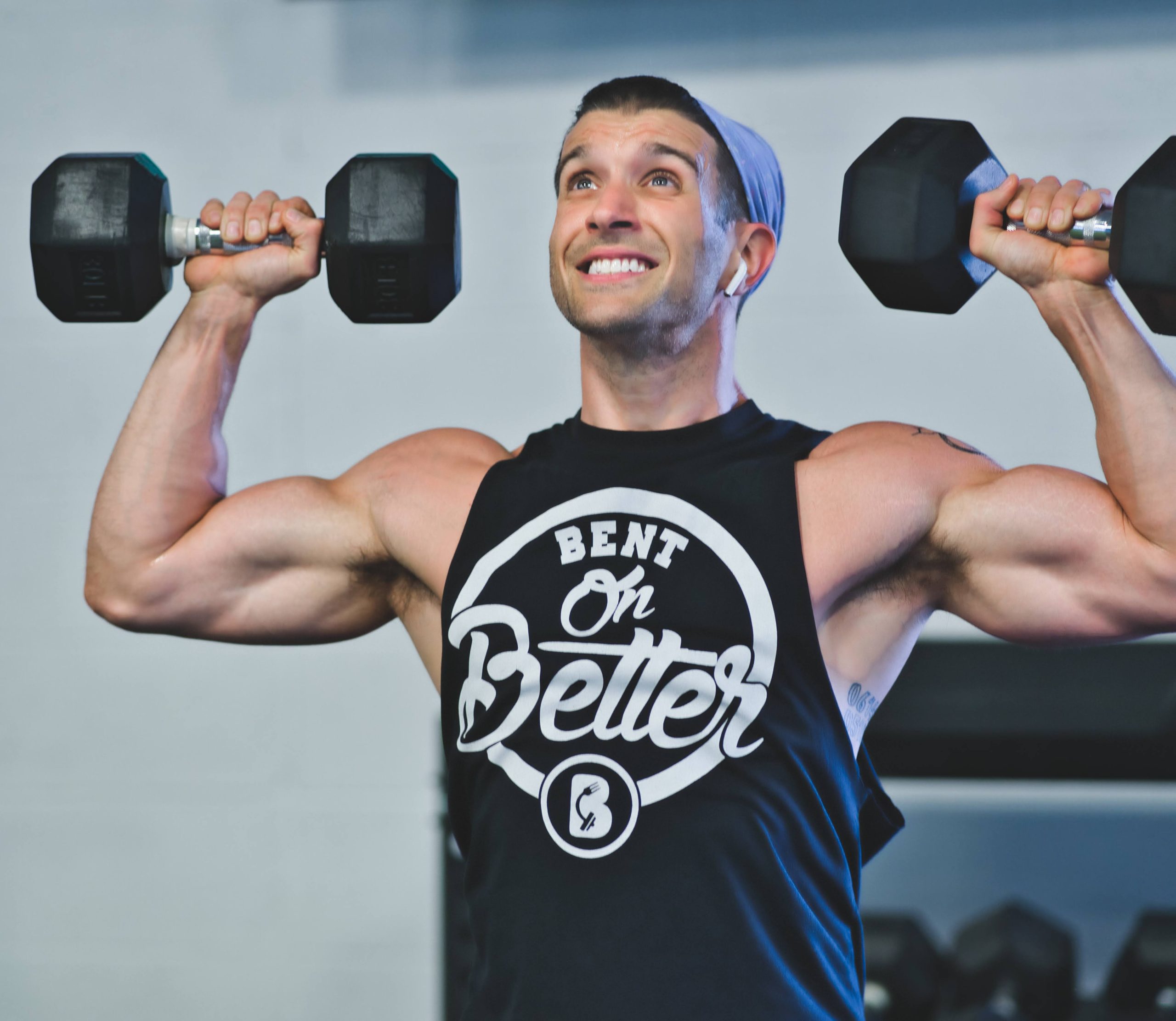 a muscular man lifting a pair of dumbbells