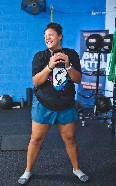A woman lifting a kettlebell in a gym